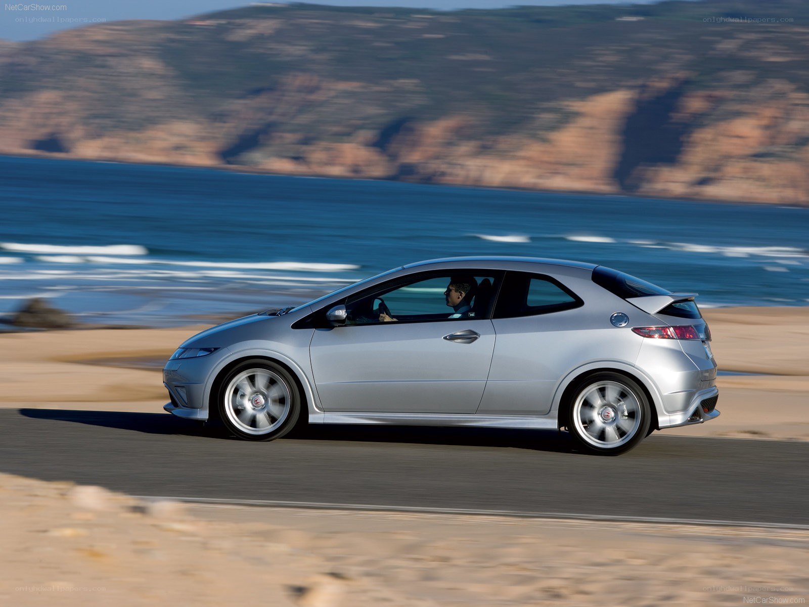 silver hatchback on coastal road