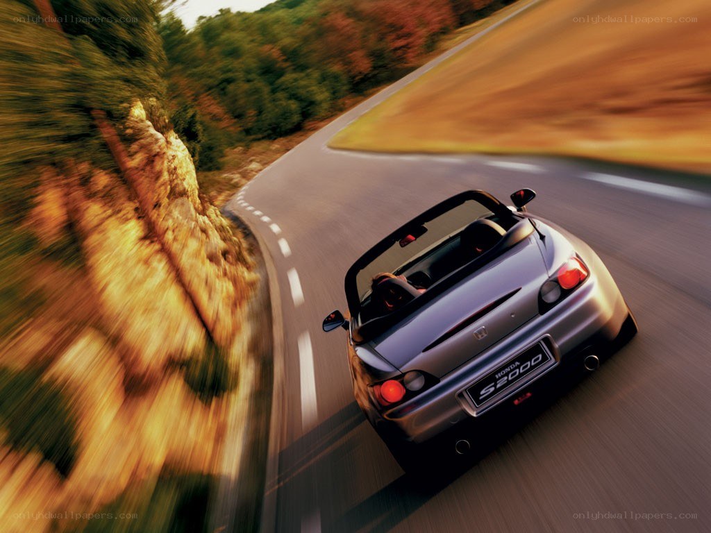 Silver Honda S2000 on a winding road