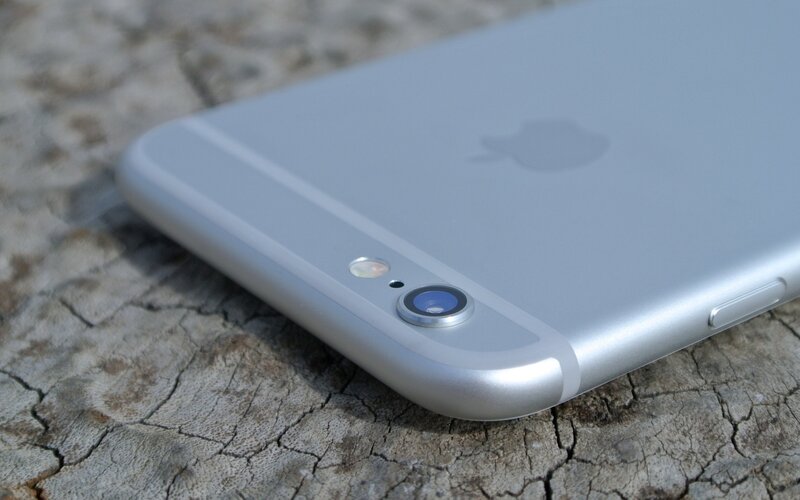 silver iphone on wood