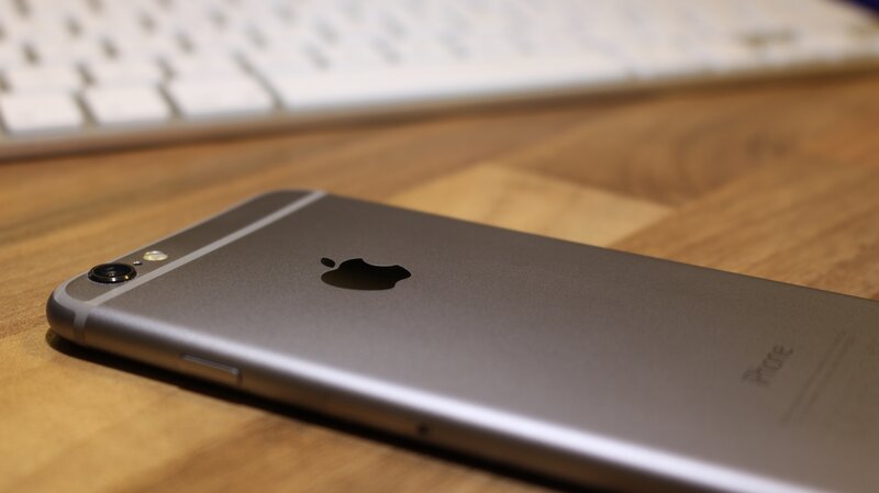 Silver iPhone on wooden desk