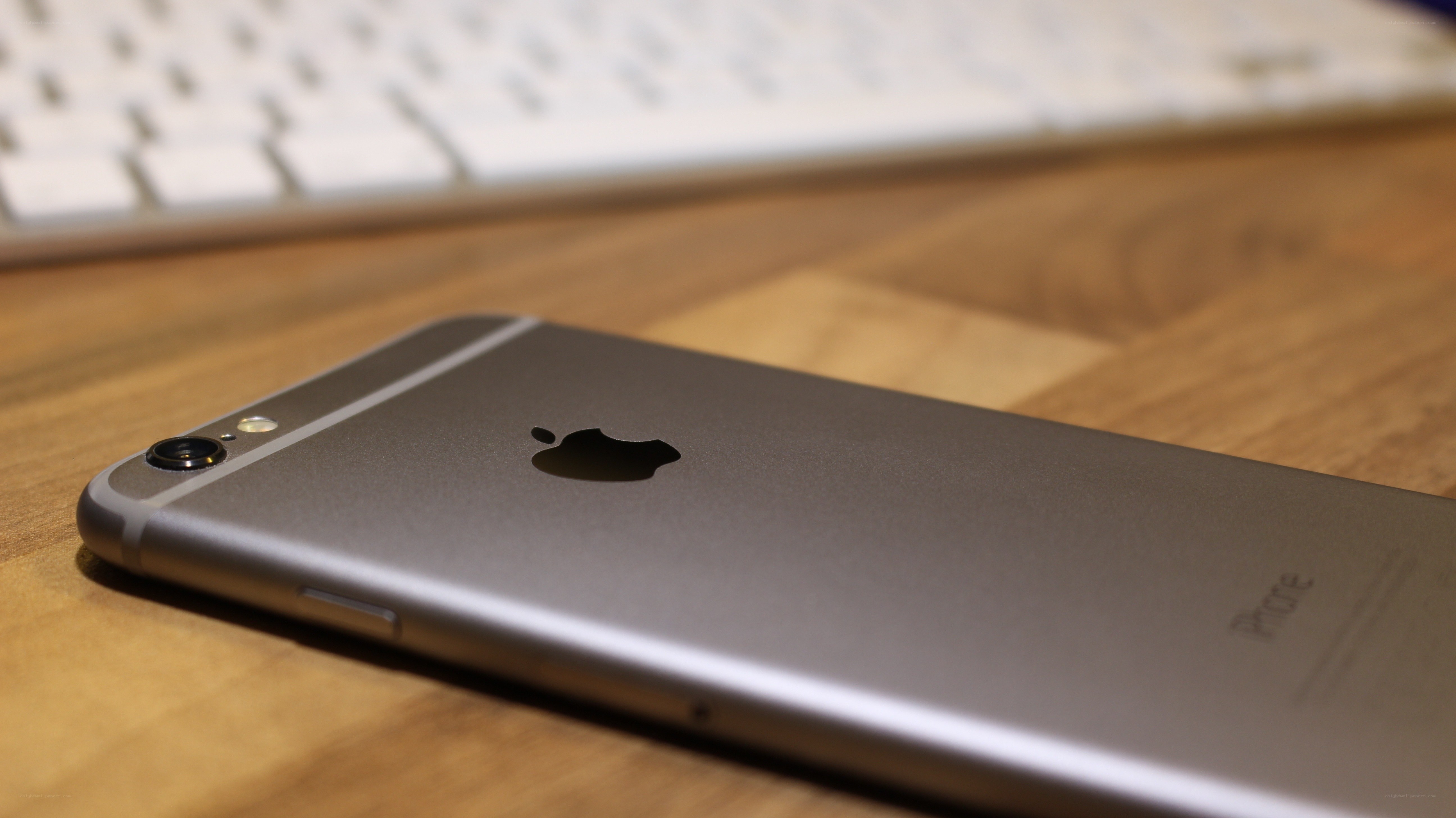 Silver iPhone on wooden desk