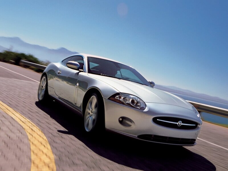silver jaguar car on coastal road