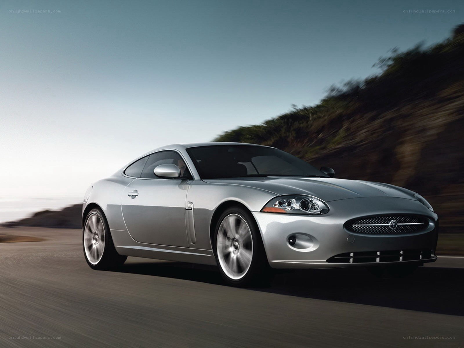 silver jaguar coupe in motion
