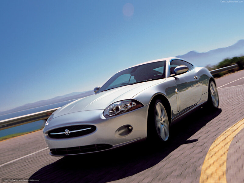 silver jaguar coupe on coastal road