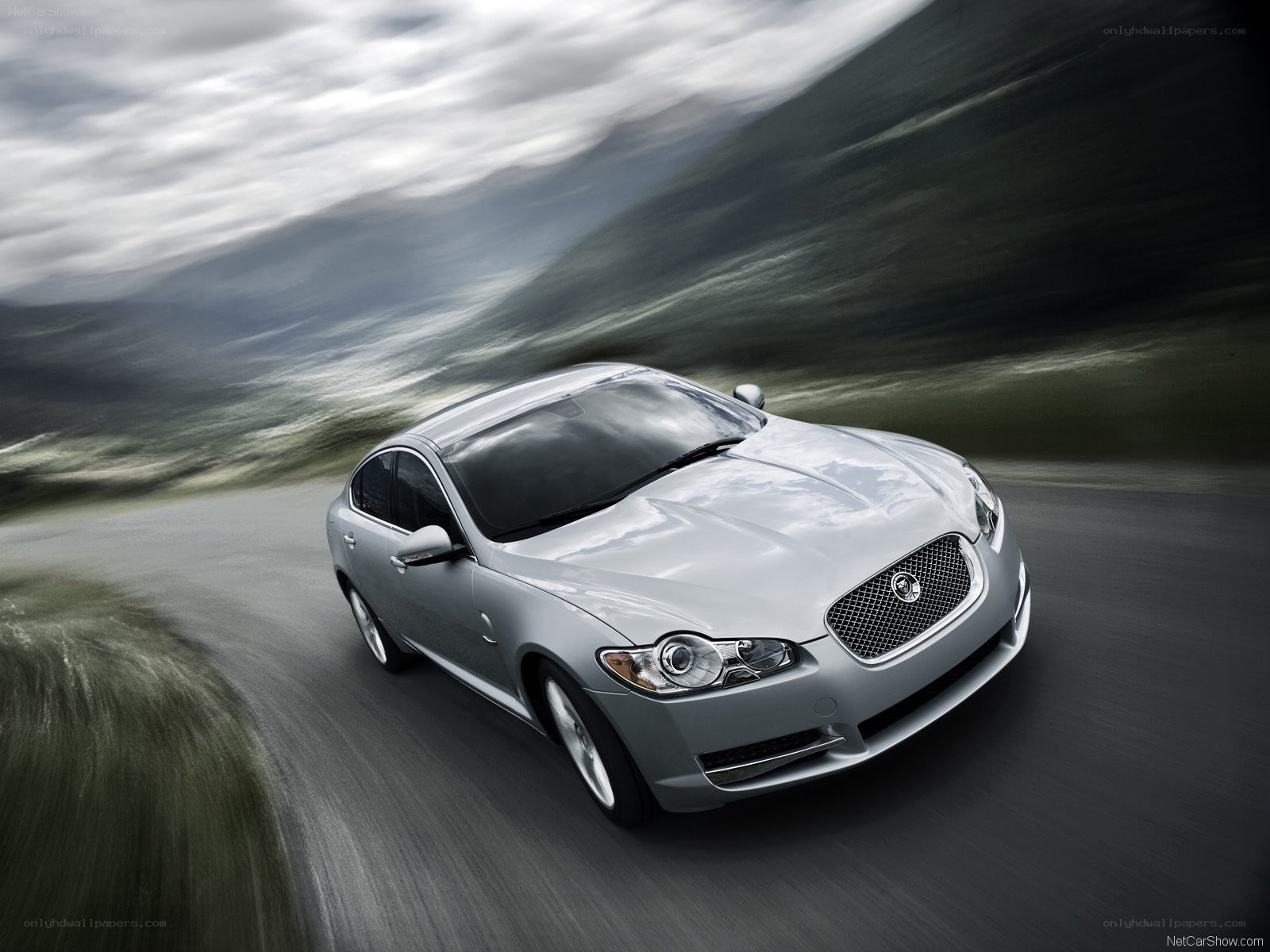silver jaguar driving on a road