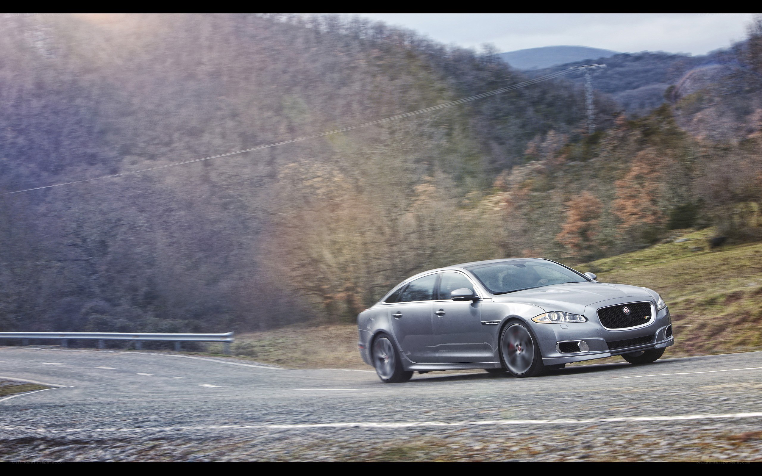 silver jaguar driving on a road
