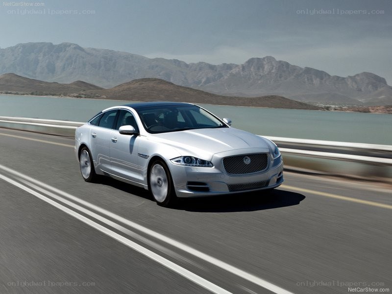 silver jaguar driving on a road