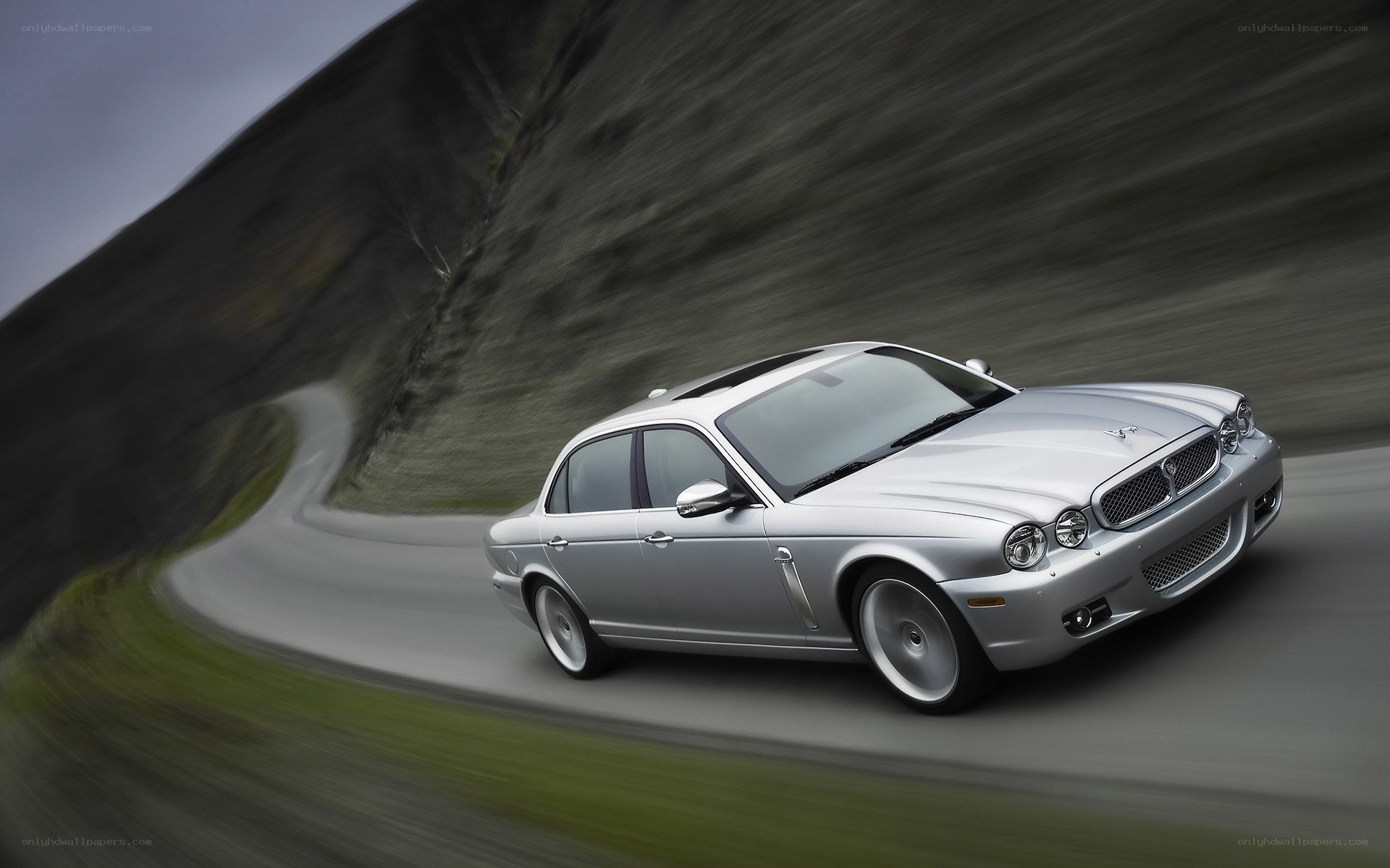 silver jaguar driving on a winding road