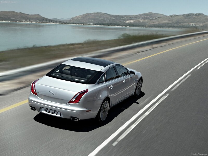 silver jaguar driving on coastal road