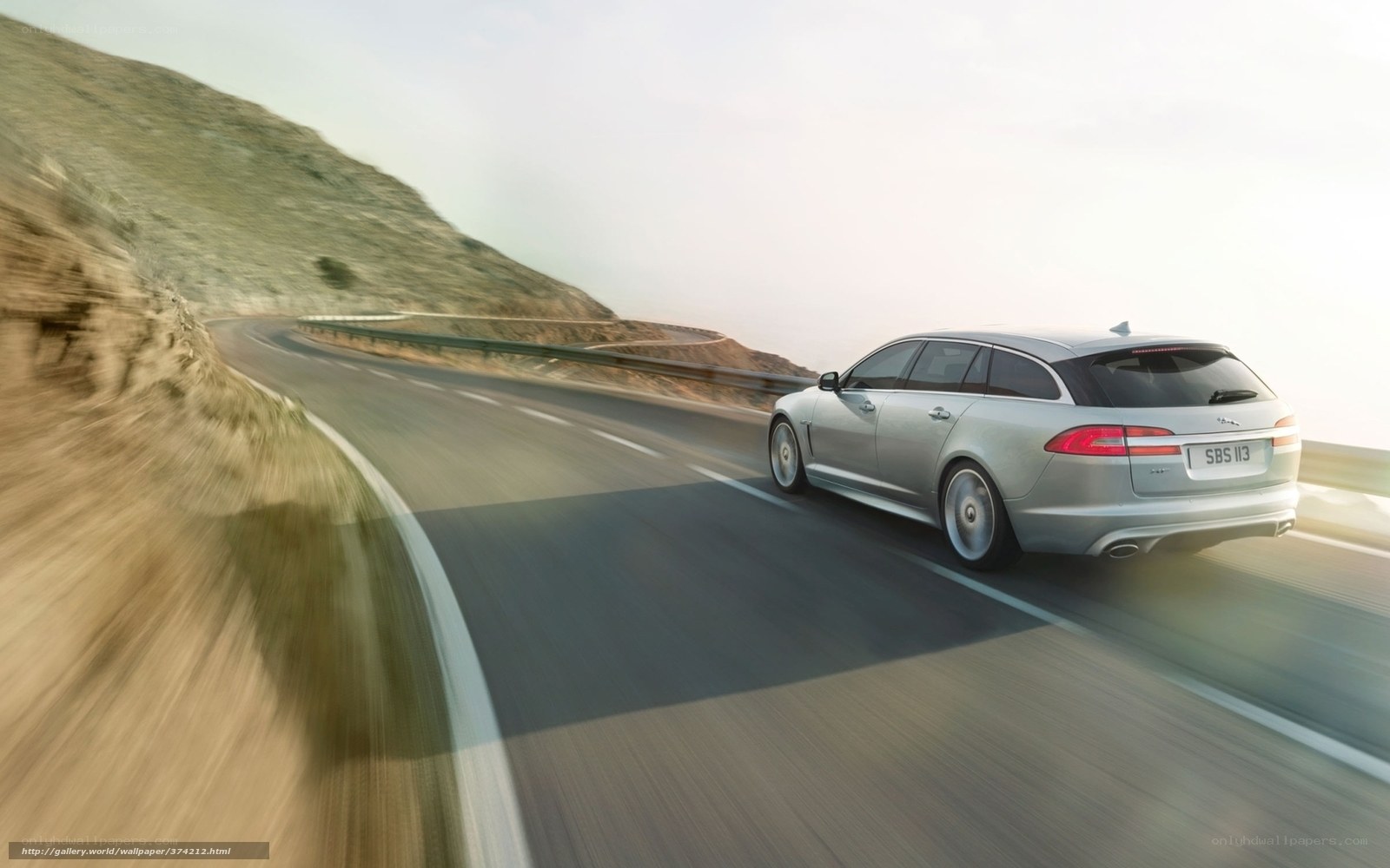 silver jaguar driving on mountain road