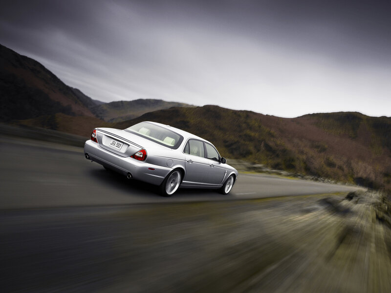 silver jaguar driving on mountain road