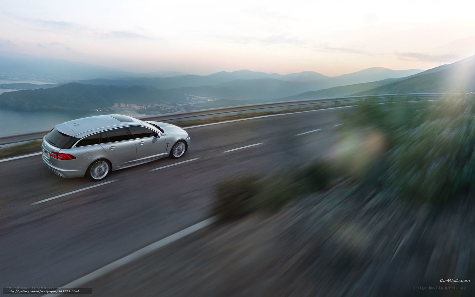 silver jaguar driving on mountain road
