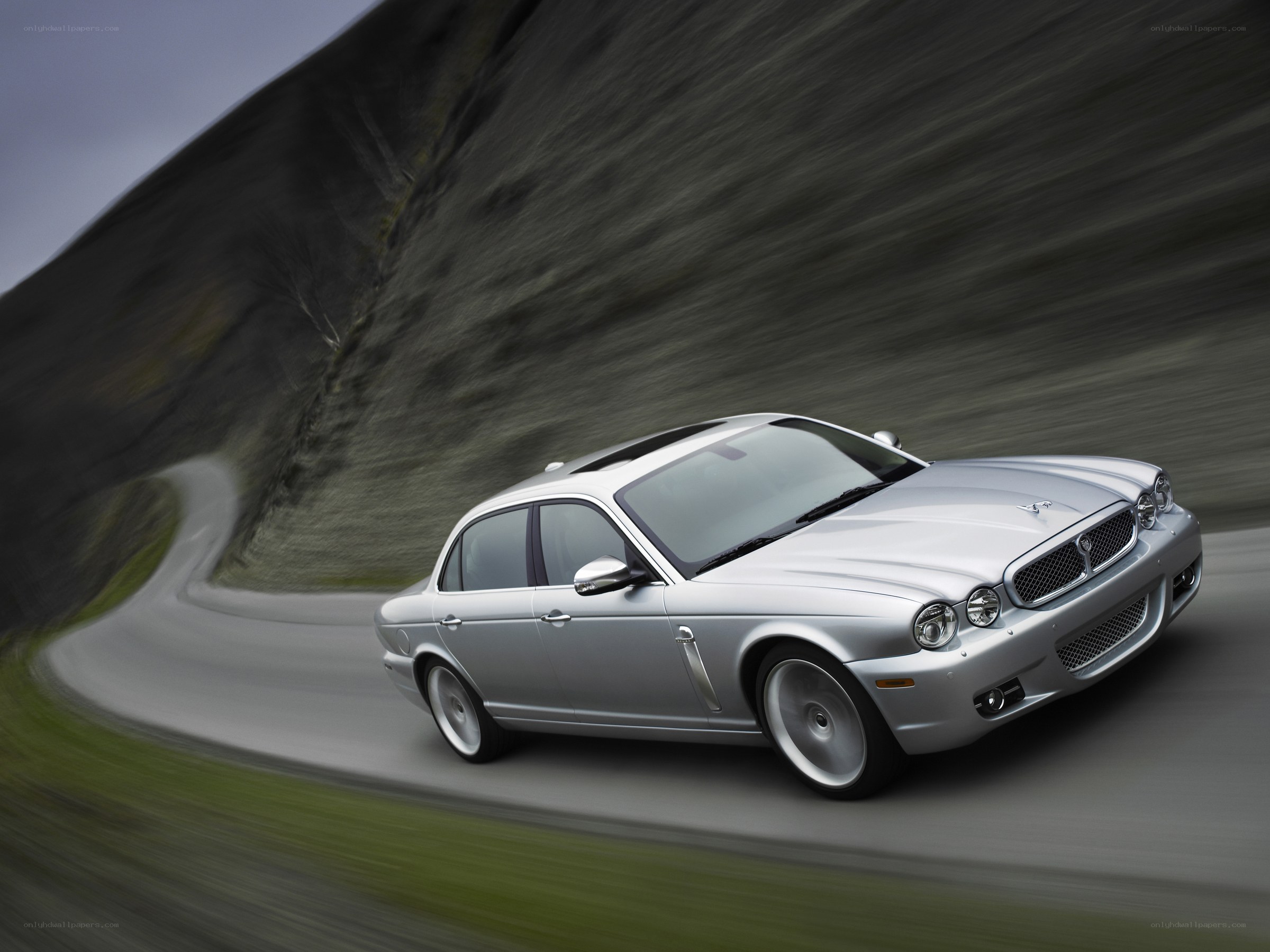 silver jaguar driving on road