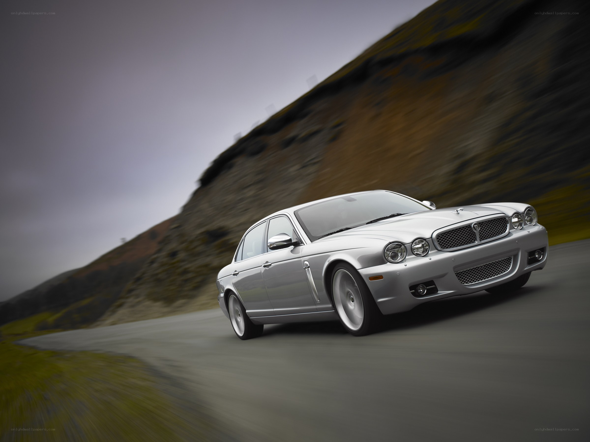silver jaguar driving on road