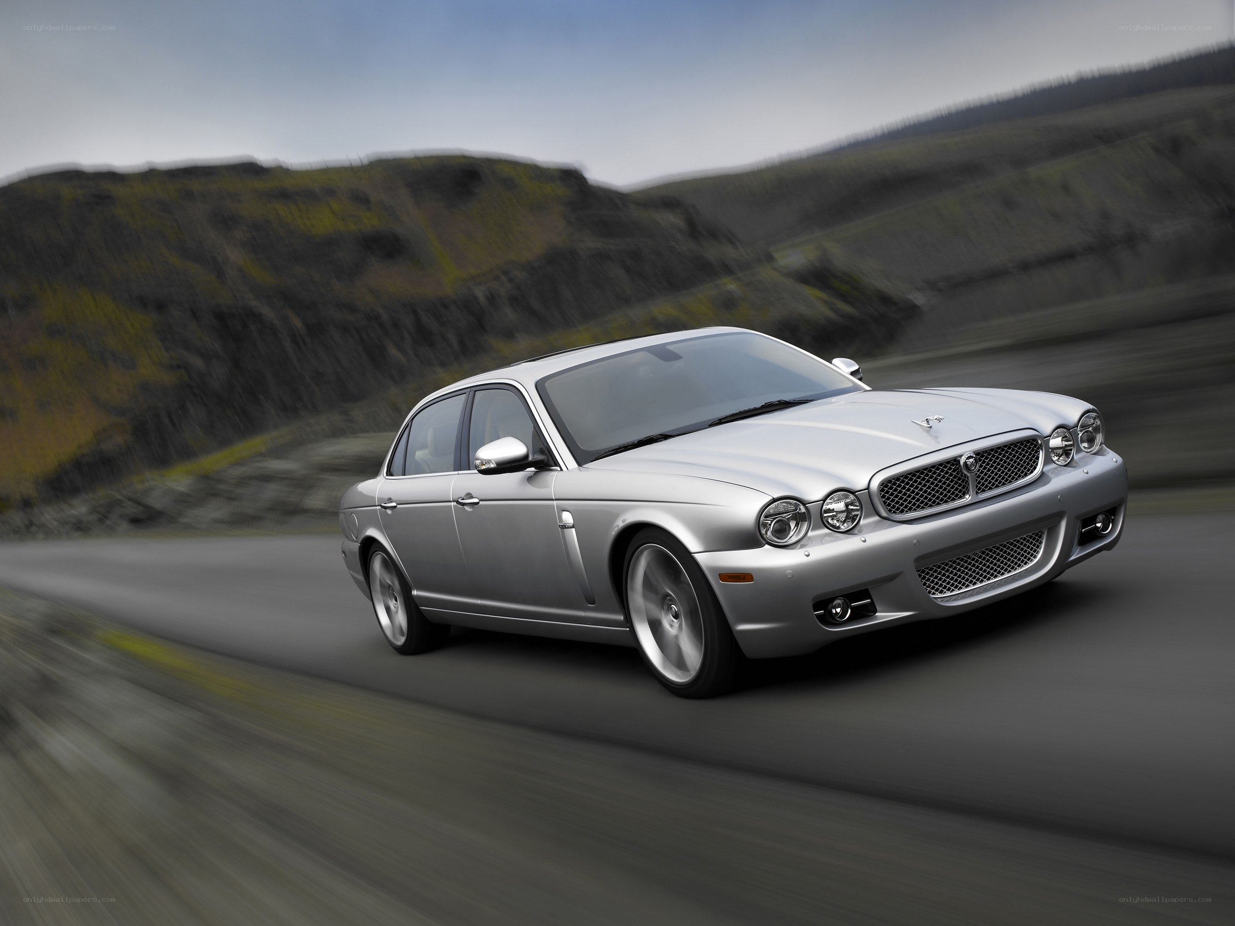 silver jaguar driving on road