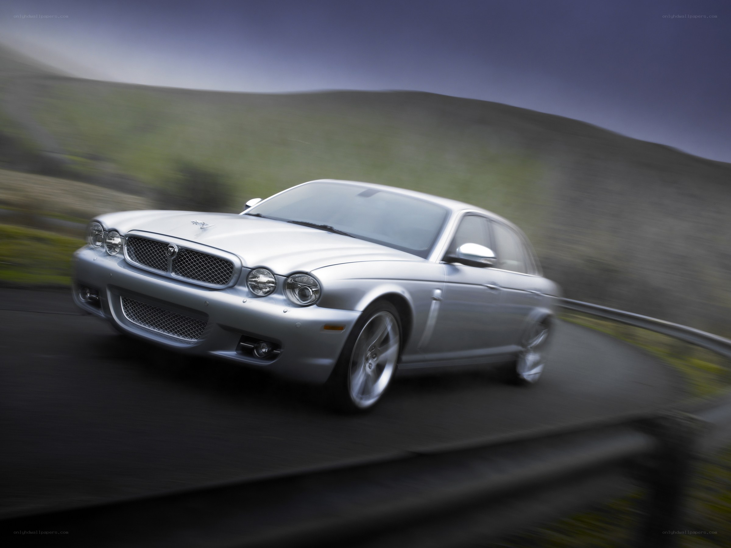 silver jaguar driving on road