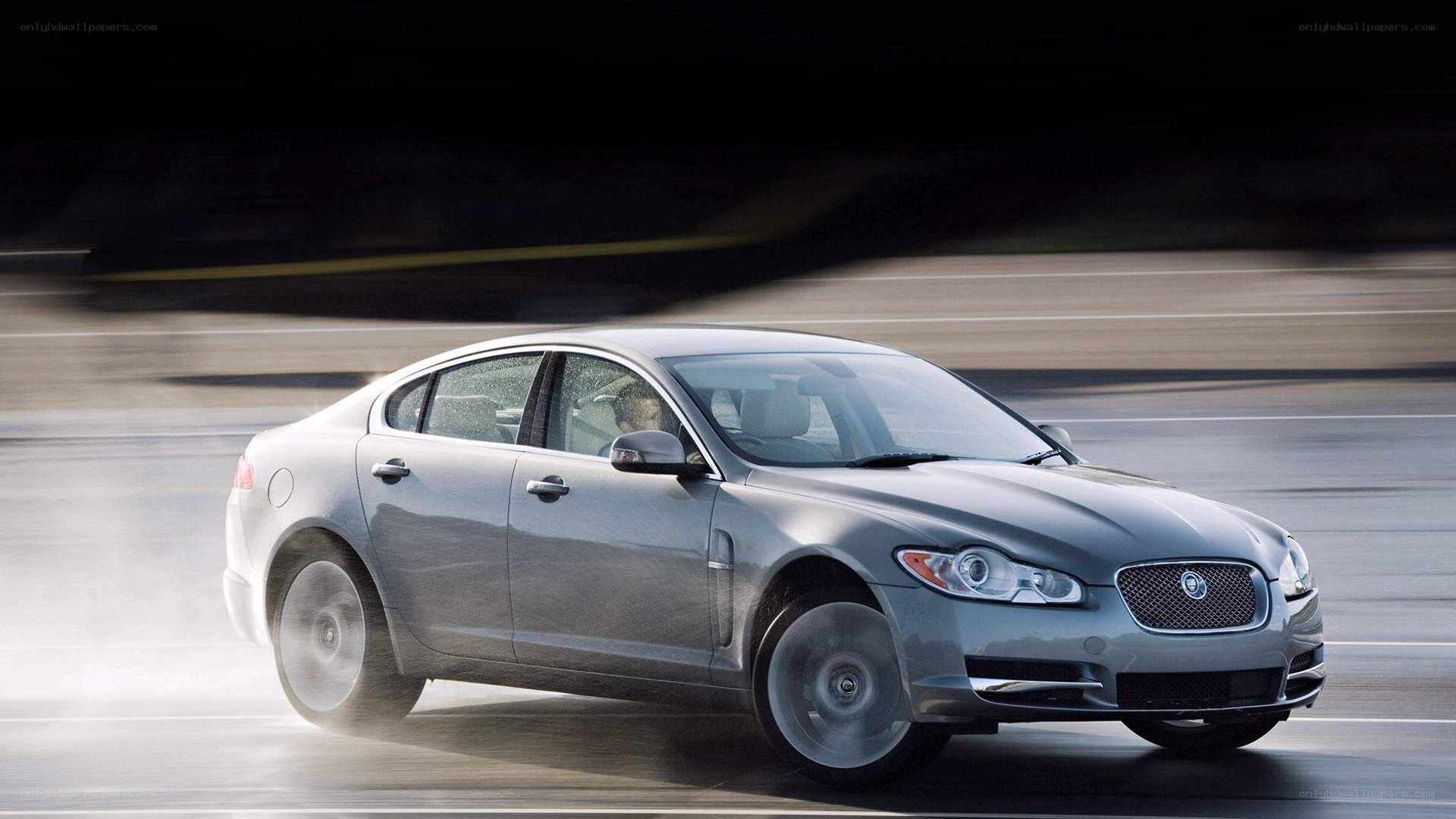 silver jaguar driving on road