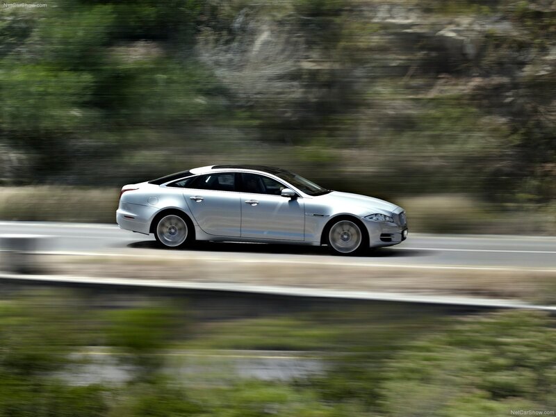 silver jaguar driving on road