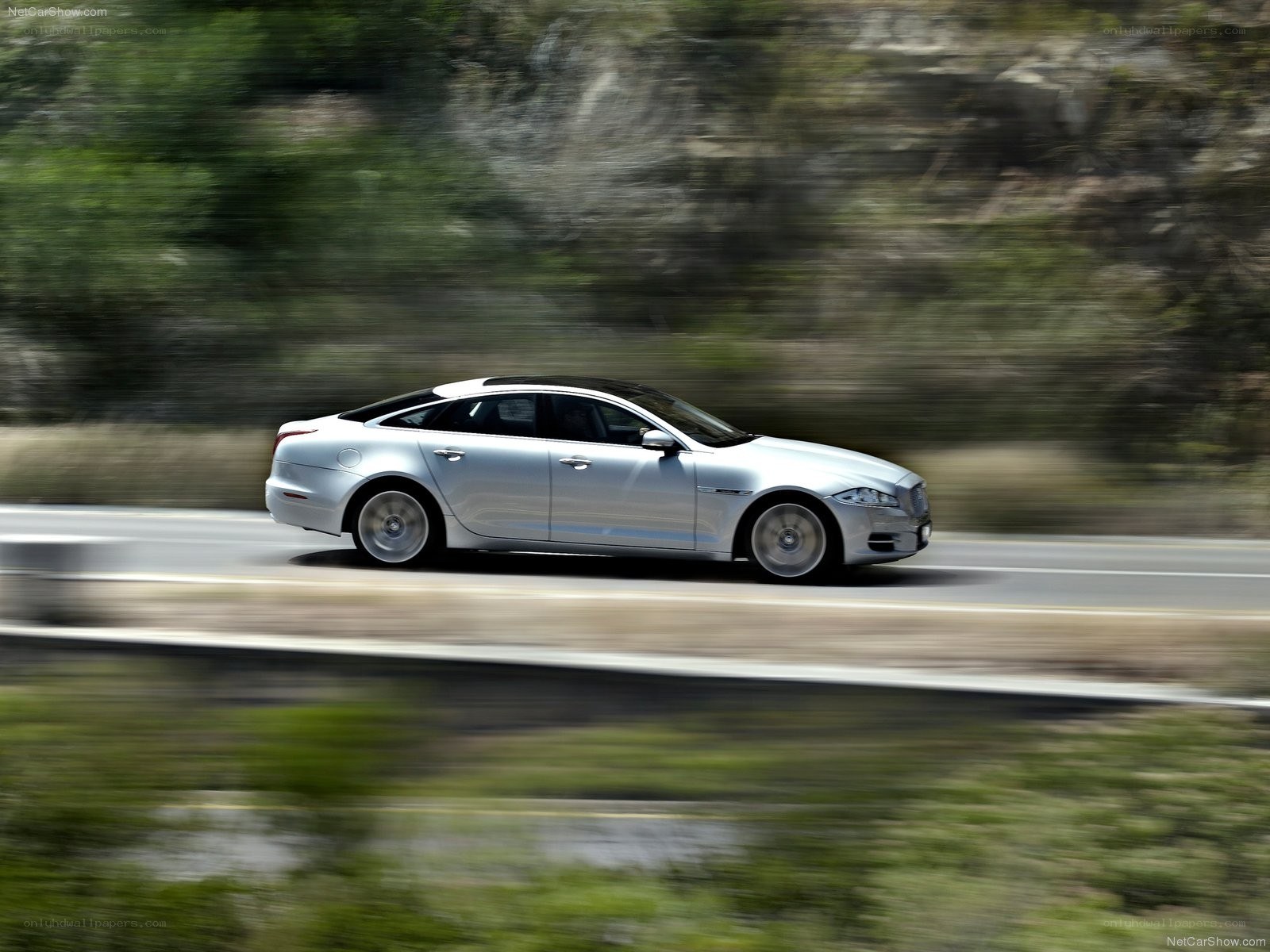 silver jaguar driving on road