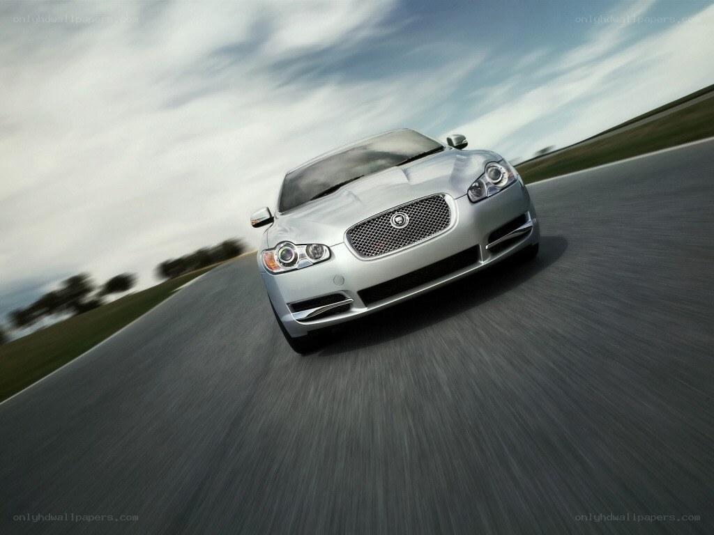 silver jaguar driving on road