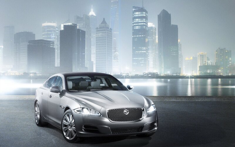 Silver Jaguar in city at night