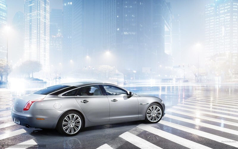 silver jaguar in city at night