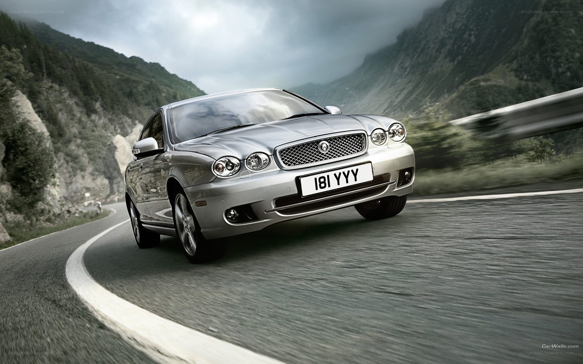 silver jaguar on mountain road