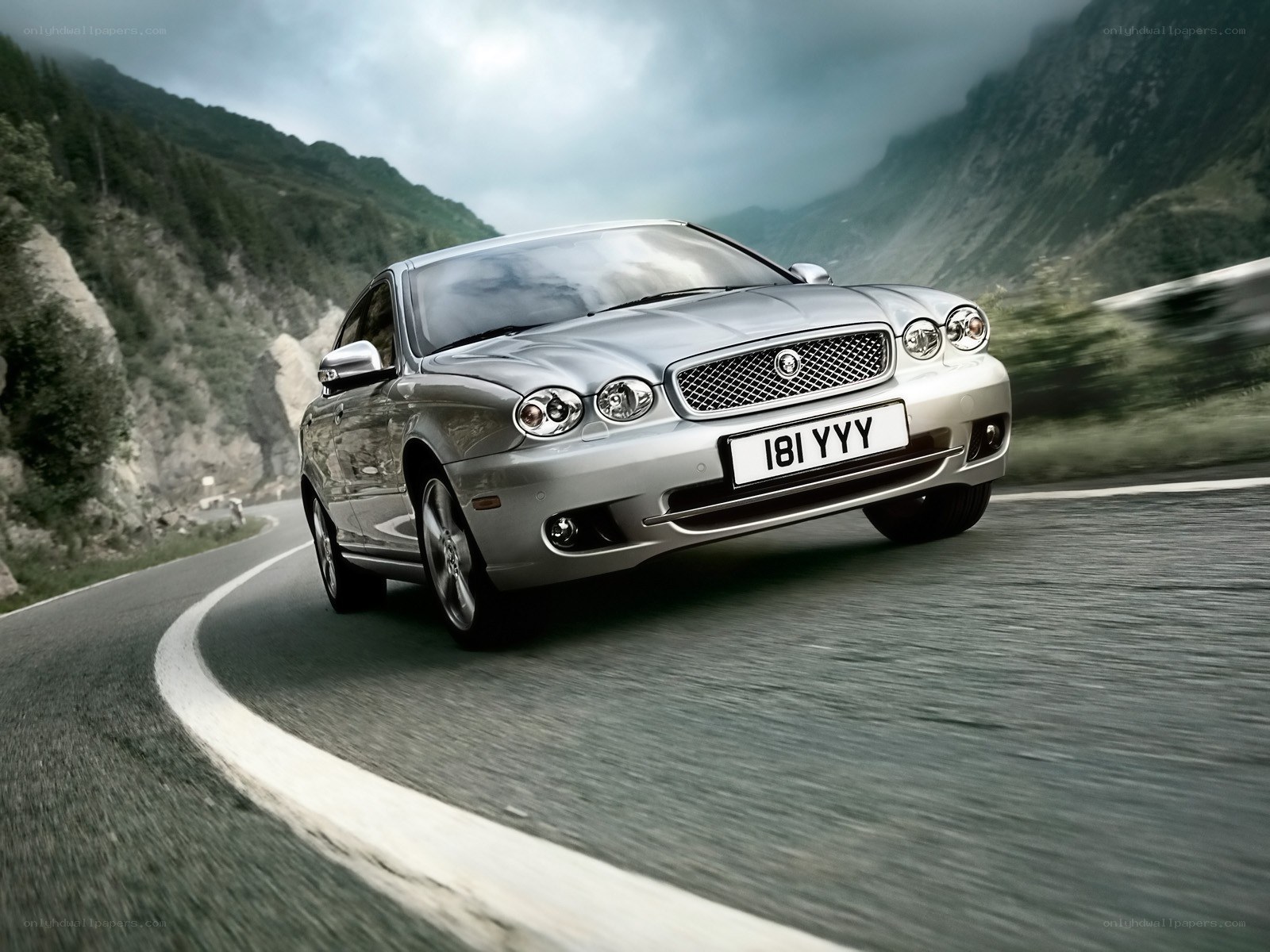 silver jaguar on mountain road