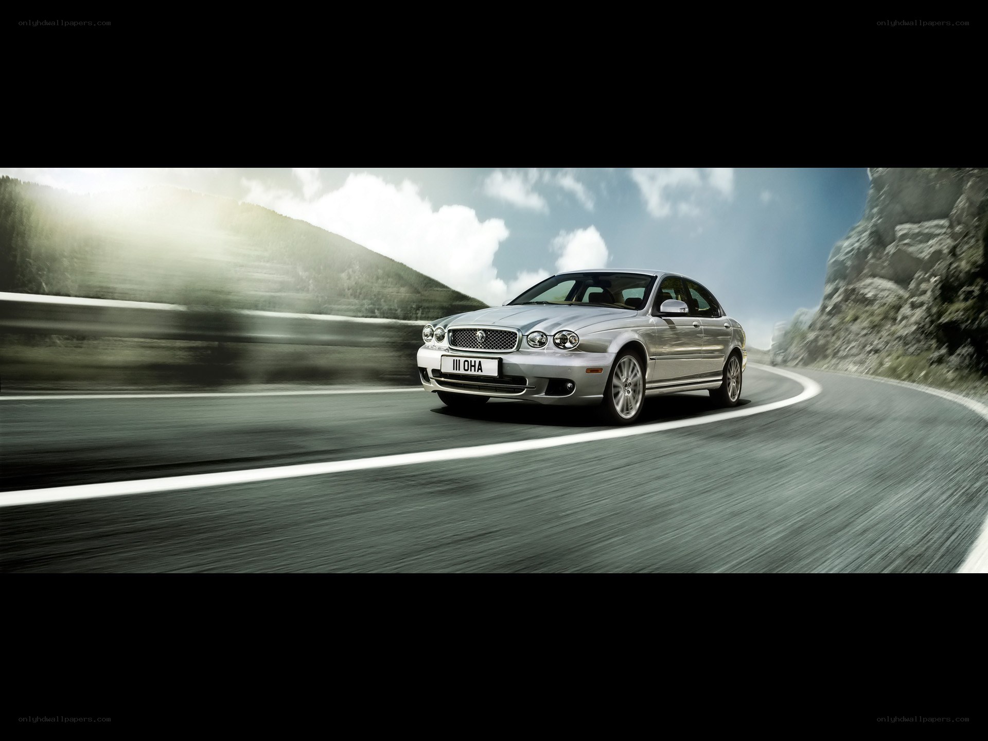 silver jaguar on winding road