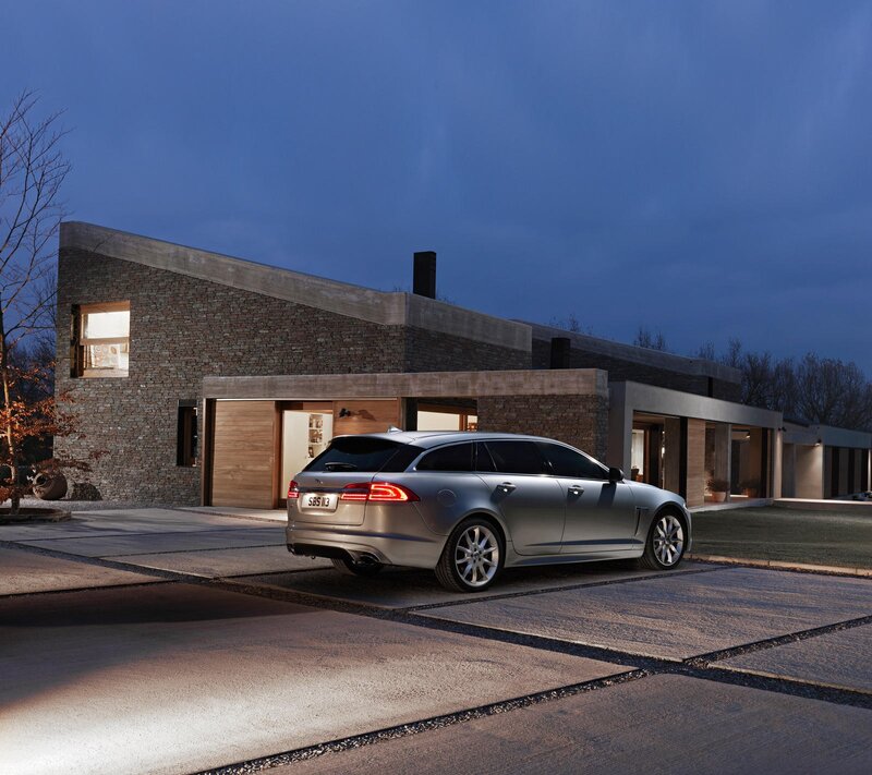 Silver Jaguar parked at modern home