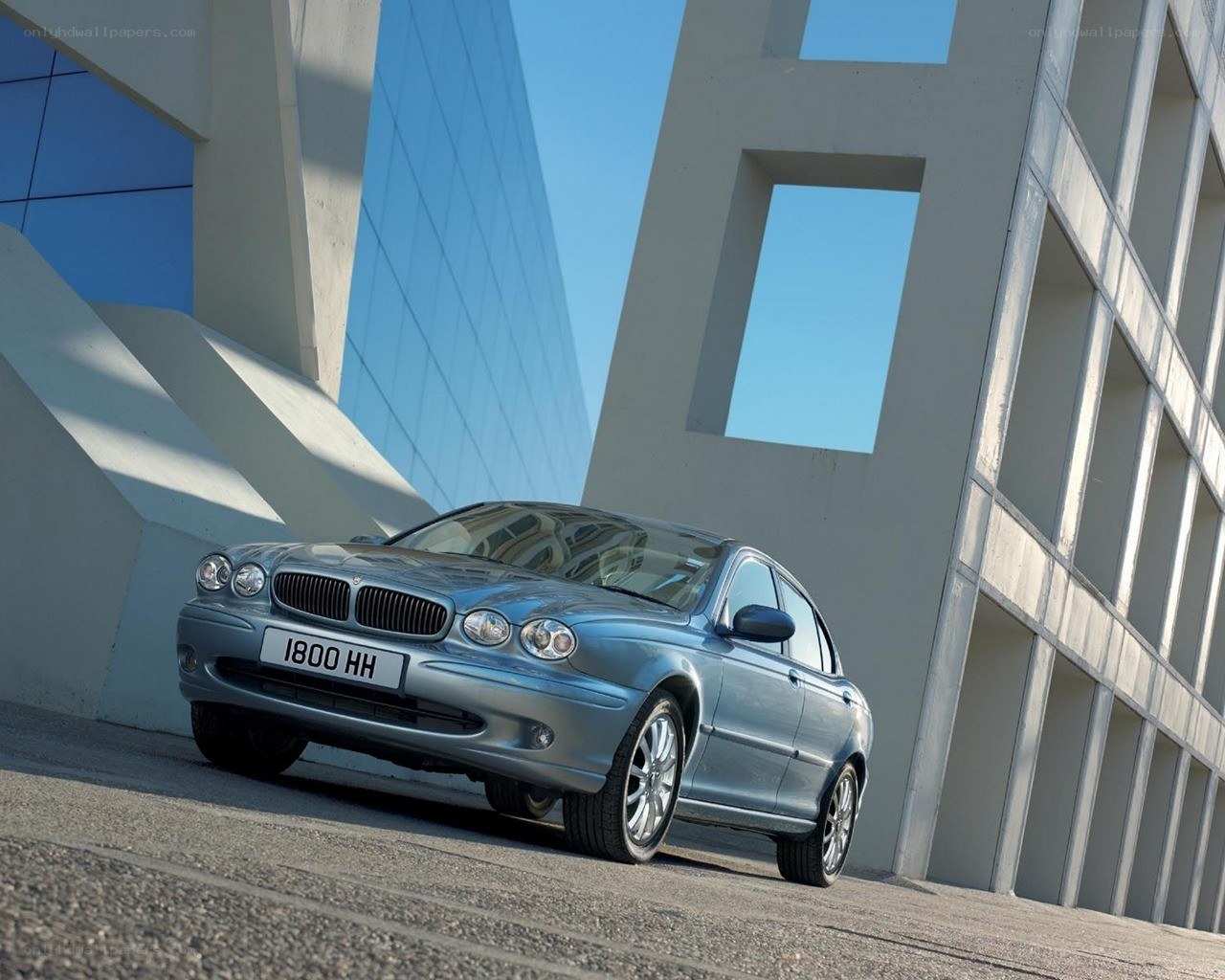 silver jaguar sedan in modern setting