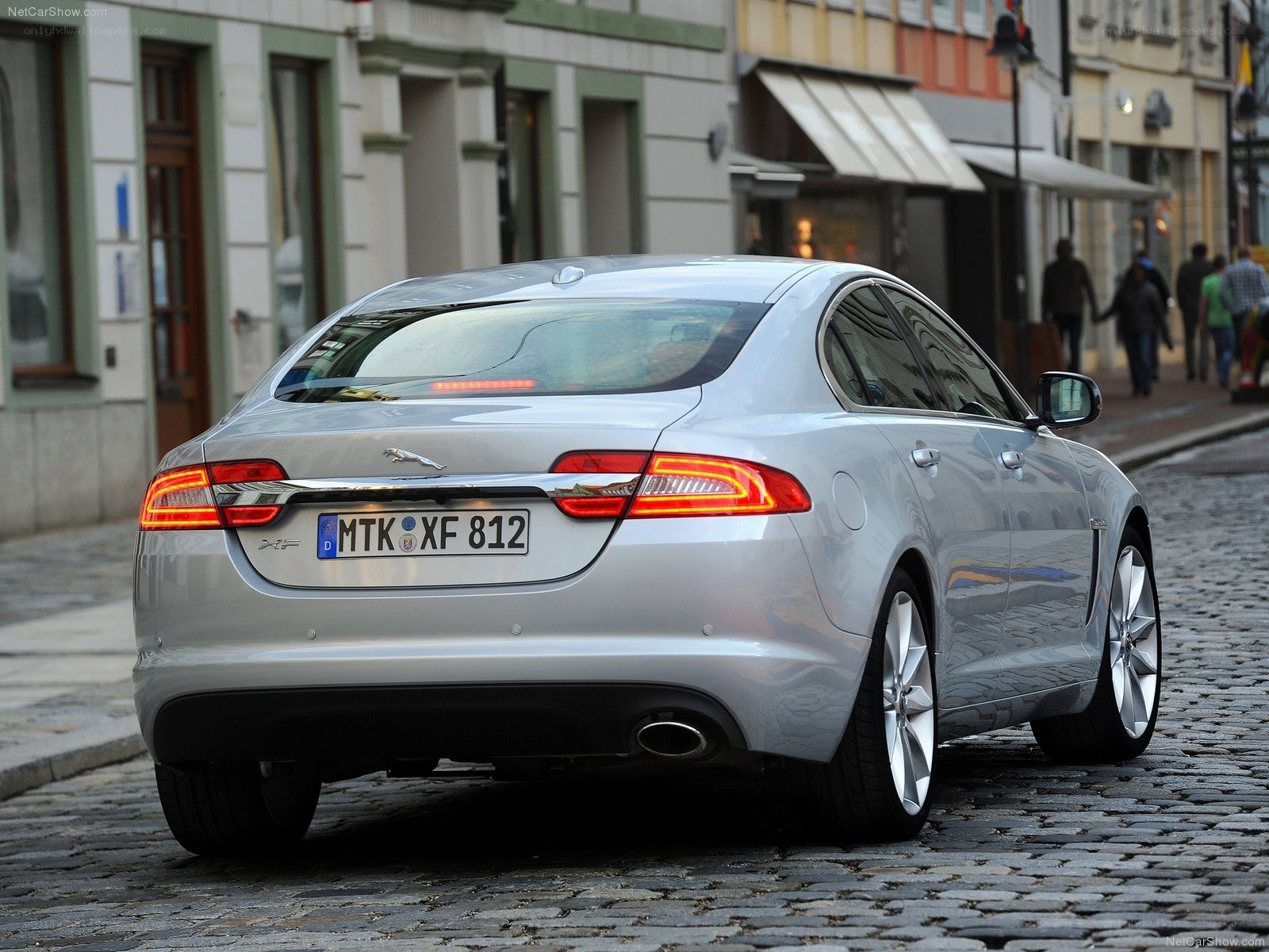 silver jaguar xf on cobblestone street