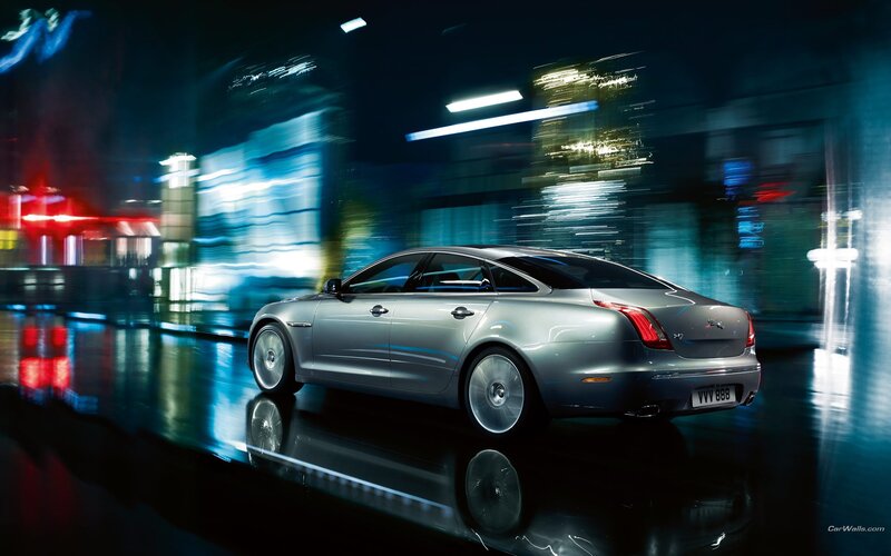 Silver Jaguar XJ in city at night