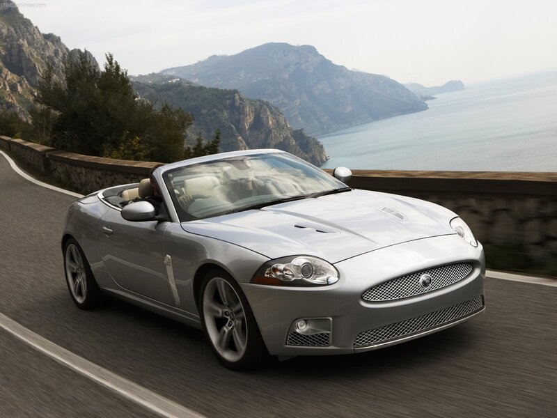 Silver Jaguar XK convertible on coastal road