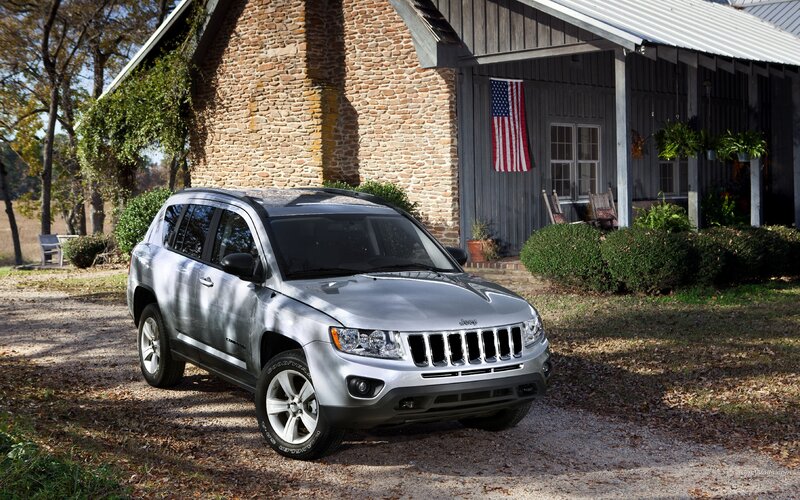 Silver Jeep Compass in front of a house