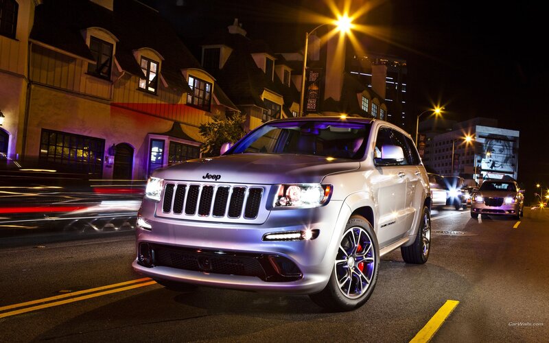 Silver Jeep on city street at night