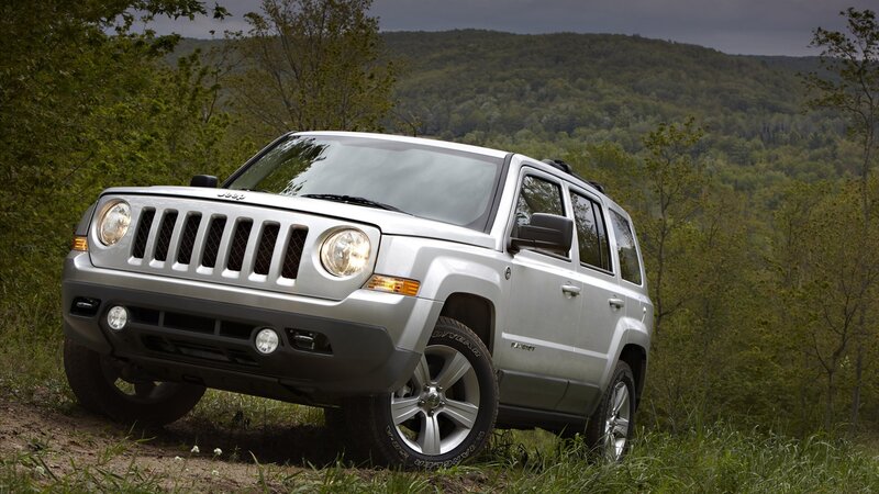 silver jeep patriot in forest