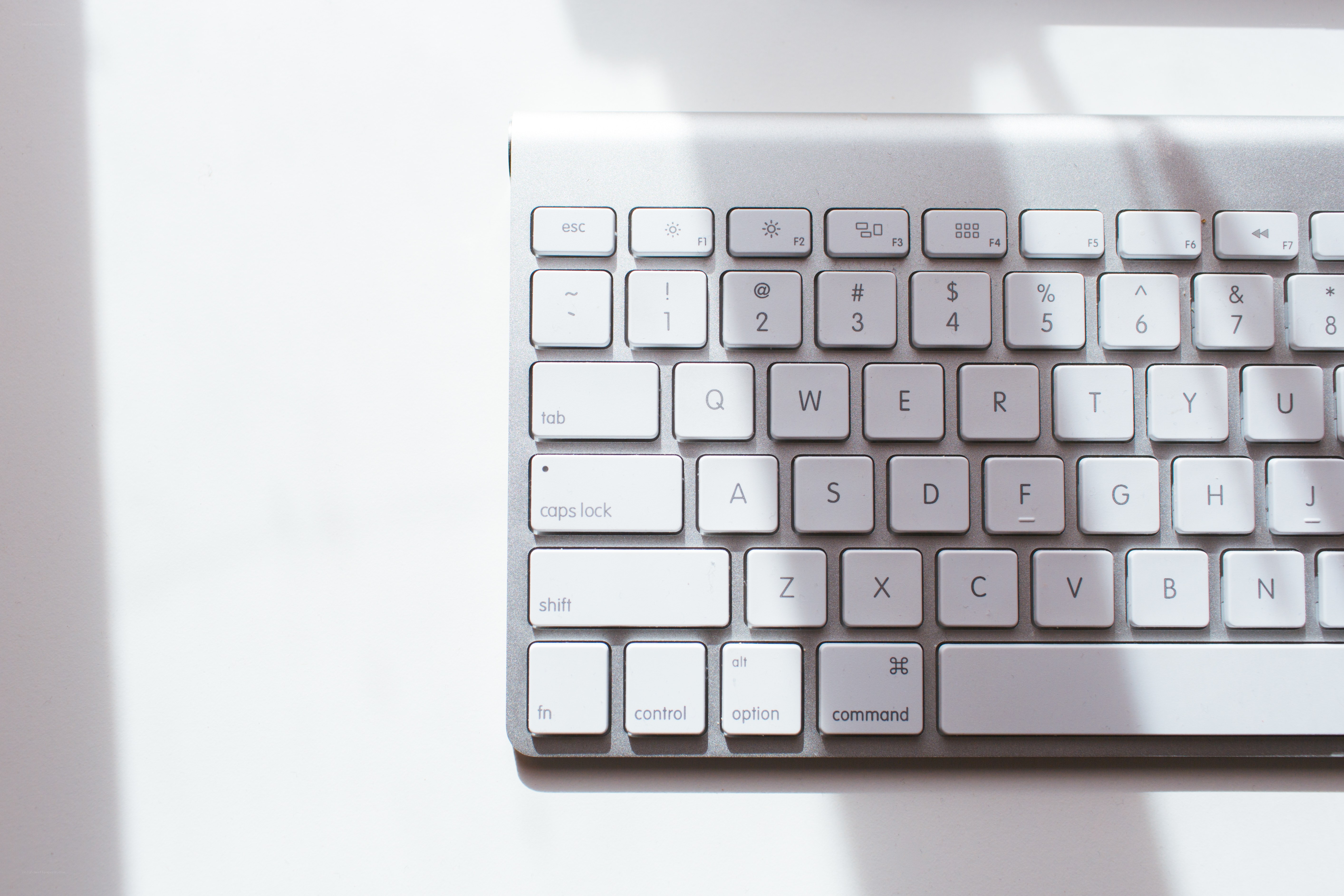 silver keyboard on white surface