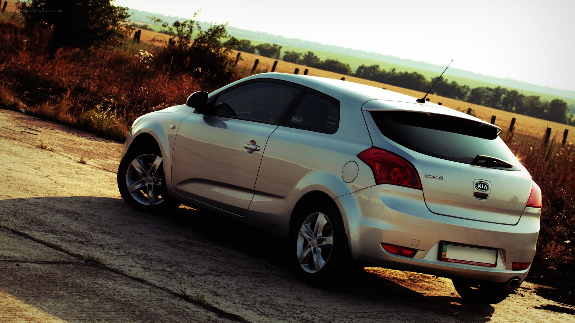 silver kia cee'd on rural road