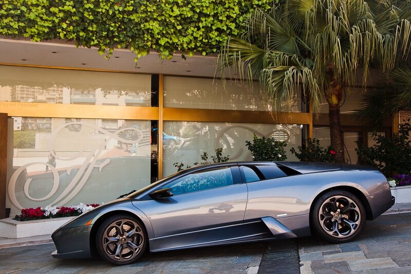 Silver Lamborghini in front of hotel