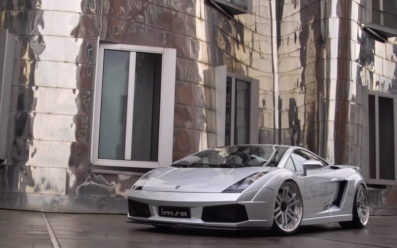 Silver Lamborghini in front of modern building
