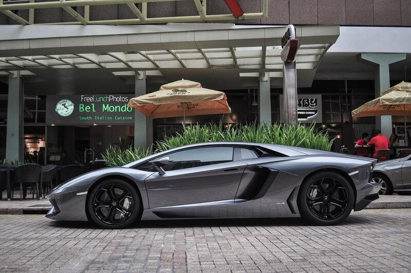 Silver Lamborghini parked outside restaurant