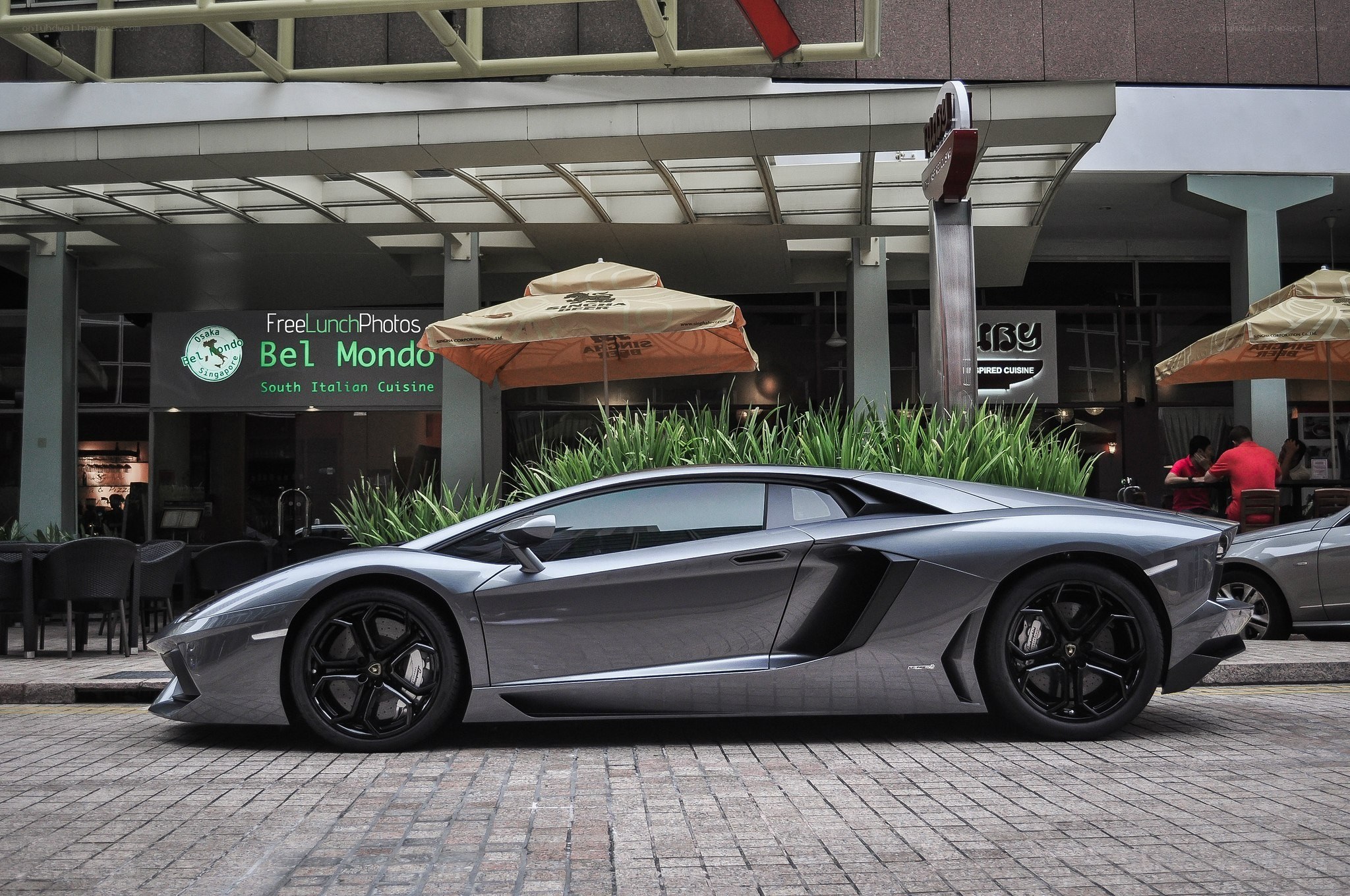 Silver Lamborghini parked outside restaurant