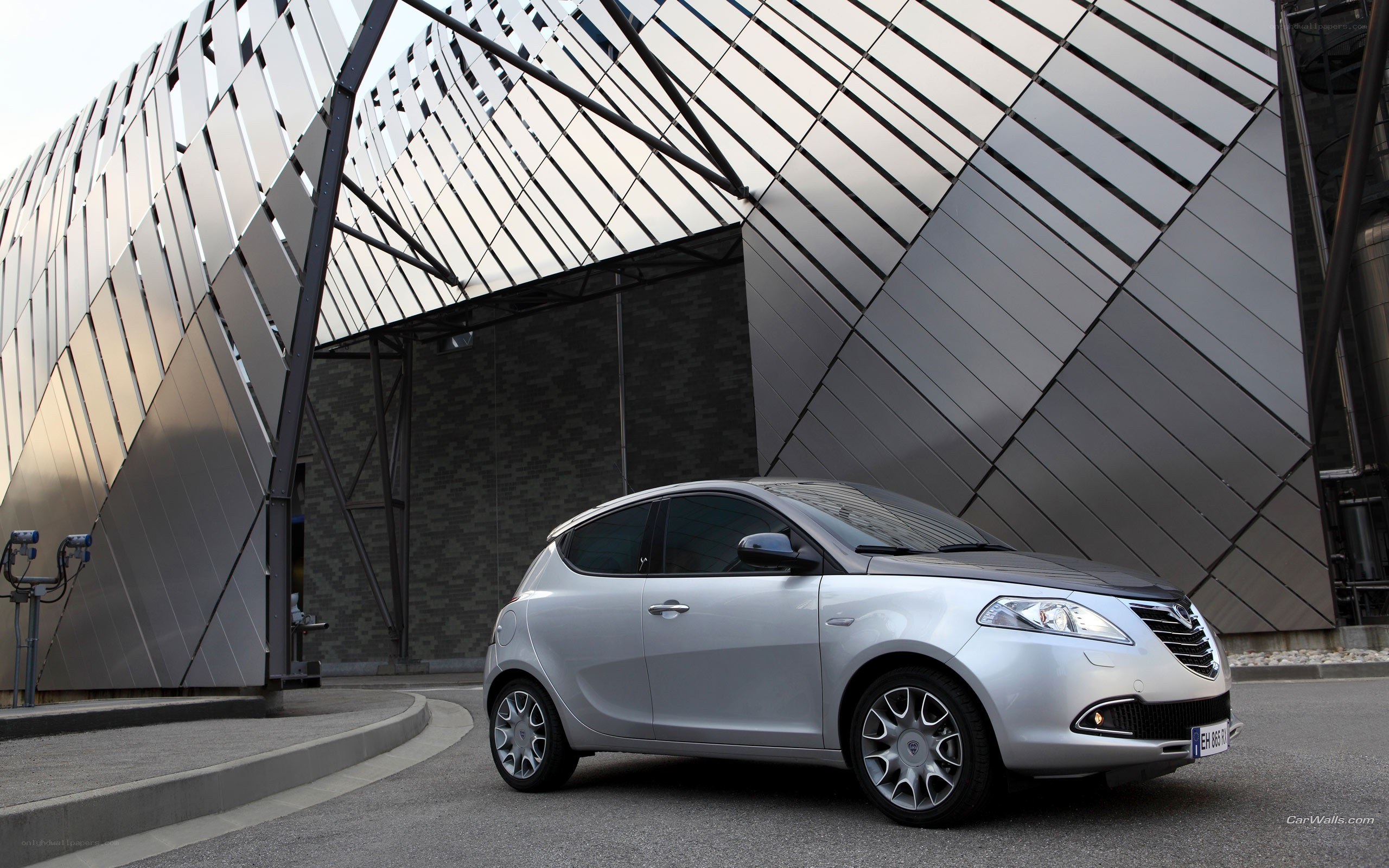 Silver Lancia Ypsilon parked outside modern building