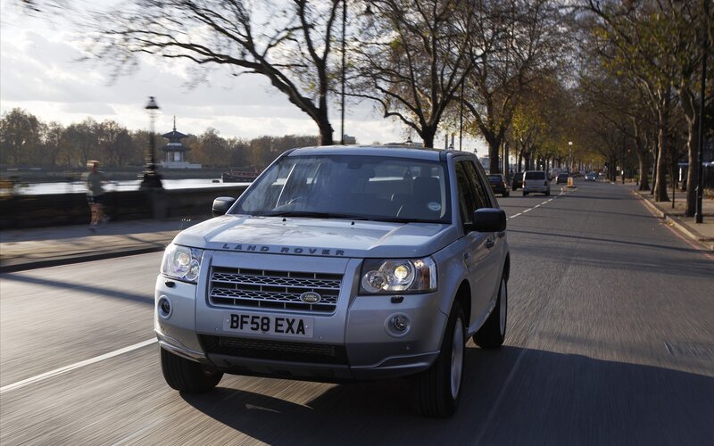Silver Land Rover driving on a city street