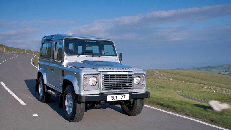 silver land rover driving on road