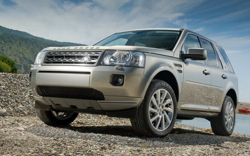 Silver Land Rover on a pebble beach