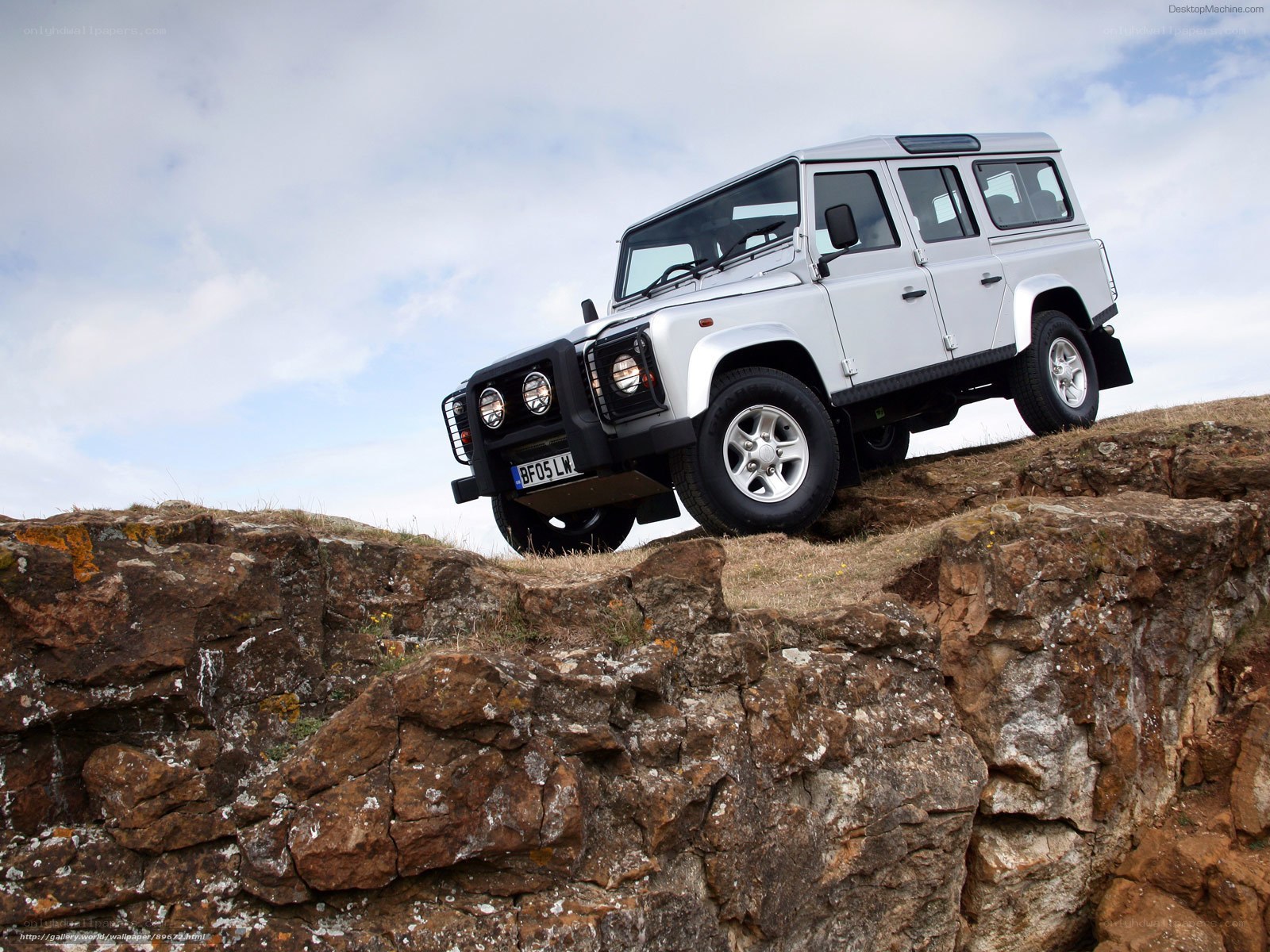 Silver Land Rover on rocky cliff