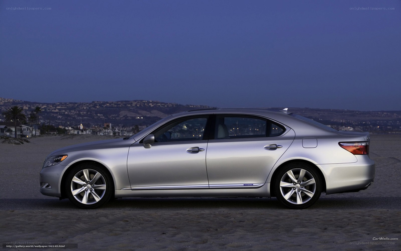 Silver Lexus LS on beach at dusk