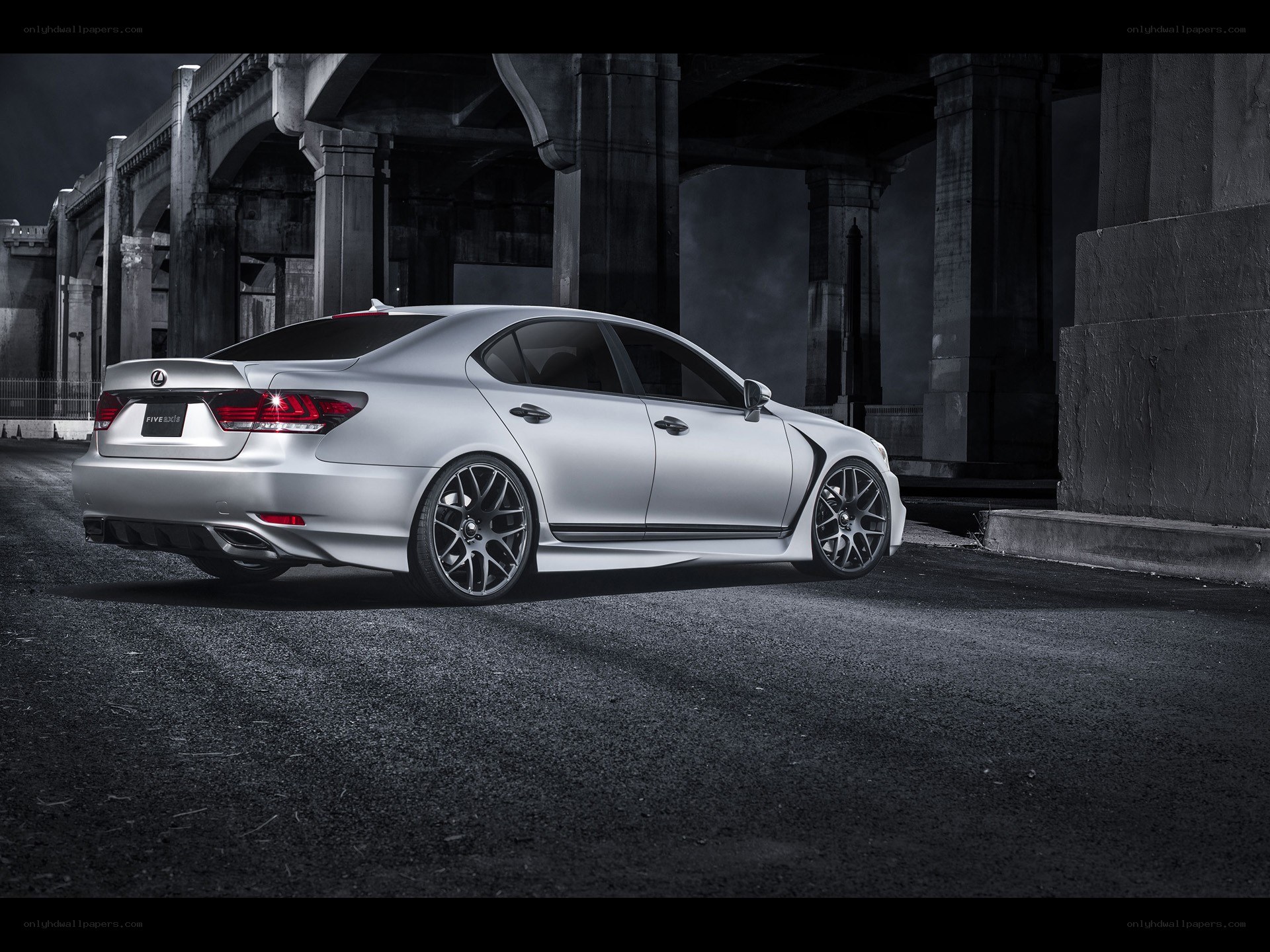 Silver Lexus under a bridge